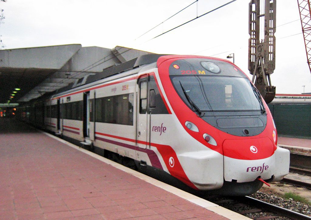 A red and silver Barcelona Airport renfe train departing from the airport