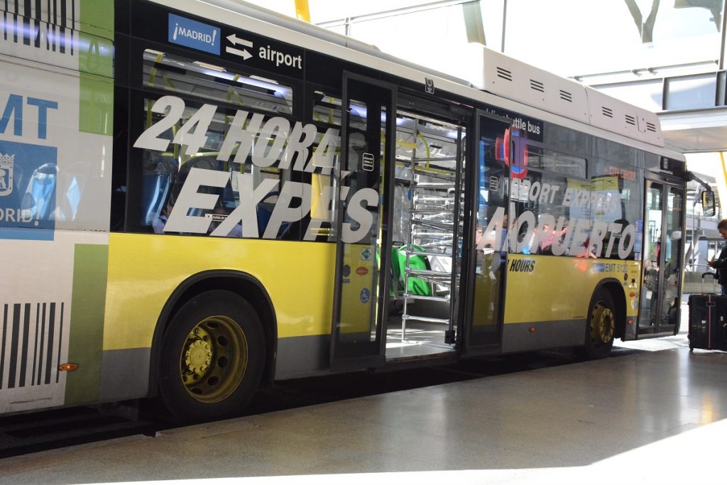 A yellow Madrid Airport bus waiting on the platform.