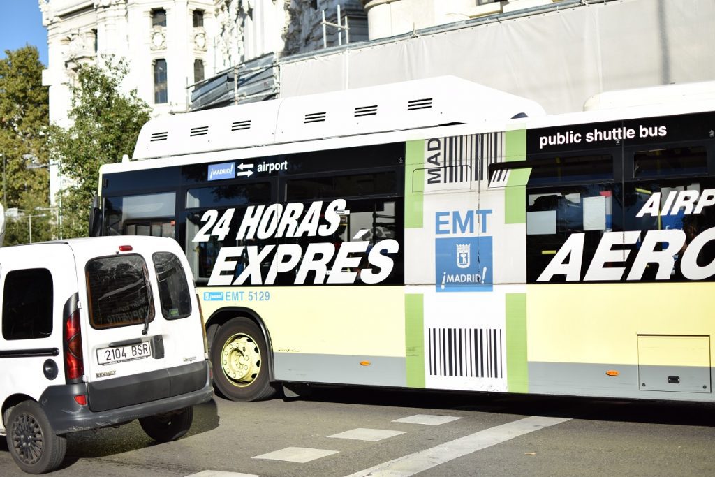 A yellow Madrid Airport Express bus arriving at the airport