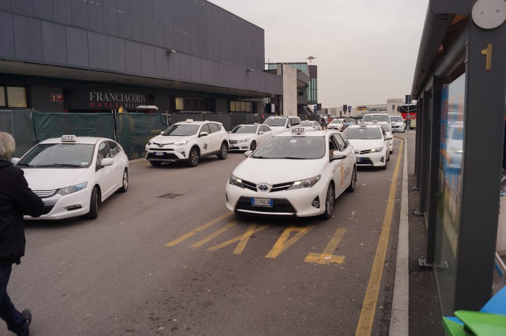 White taxis lined up in the Bergamo Airport taxi rank.