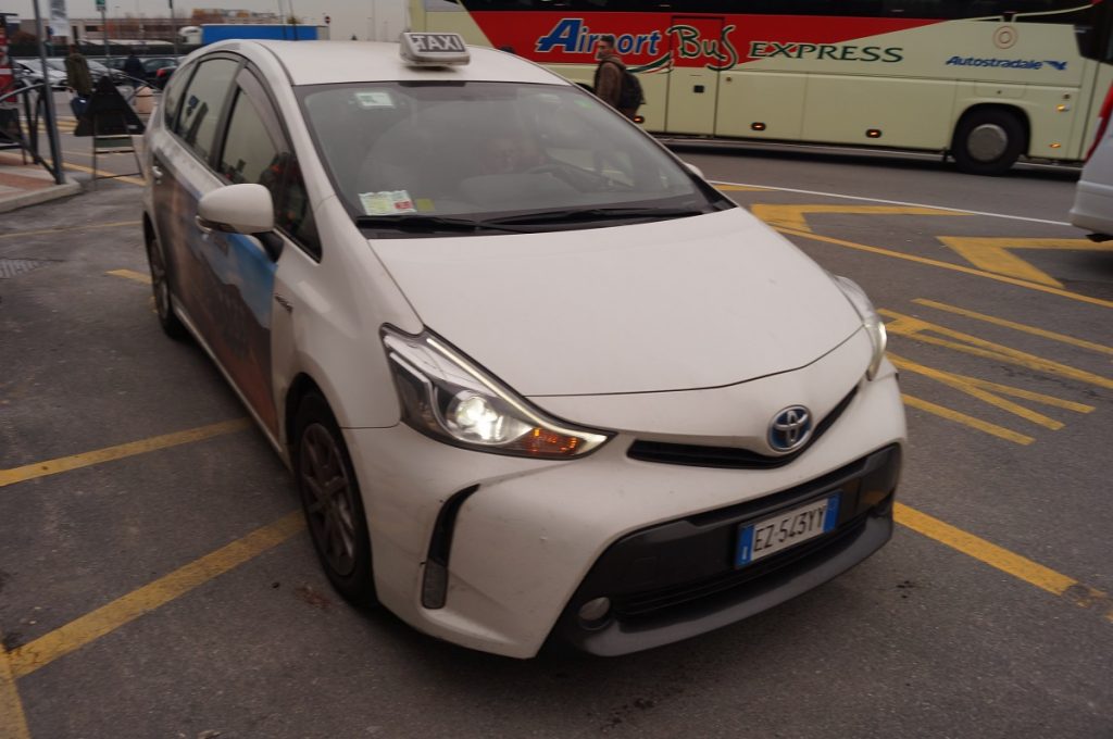 A white Bergamo Airport taxi