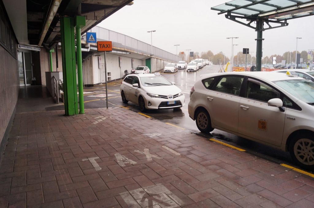 White Milan Linate Airport taxis at the airport taxi rank offering rides from Linate Airpot to Milan city center