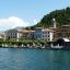 Large colorful houses along the shoreline of Lake Como on a sunny day.