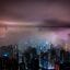 Hong Kong city center lit up at night under a purple haze.
