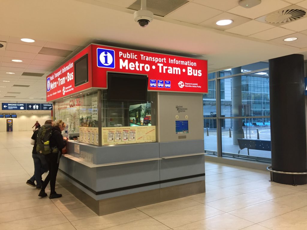 Prague Airport Public Transport Information counter with red signage, for metro, tram and bus.