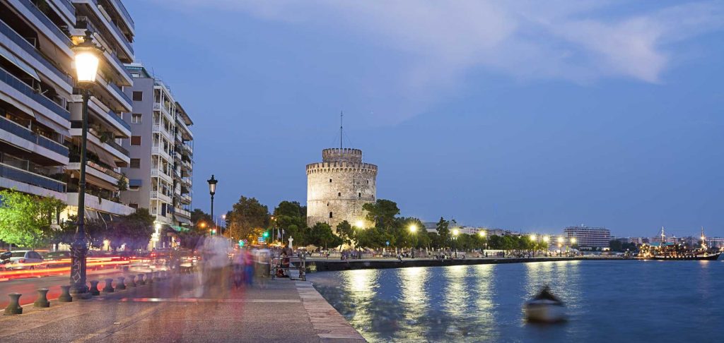 Thessaloniki promenade waterway and buildings at night.