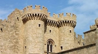 Castle building with light sandy stone against a blue sky