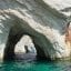 White rocks in turquoise waters with an arch through the centre.