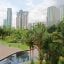 Gardens and park walkway before the tall buildings of Kuala Lumpur.