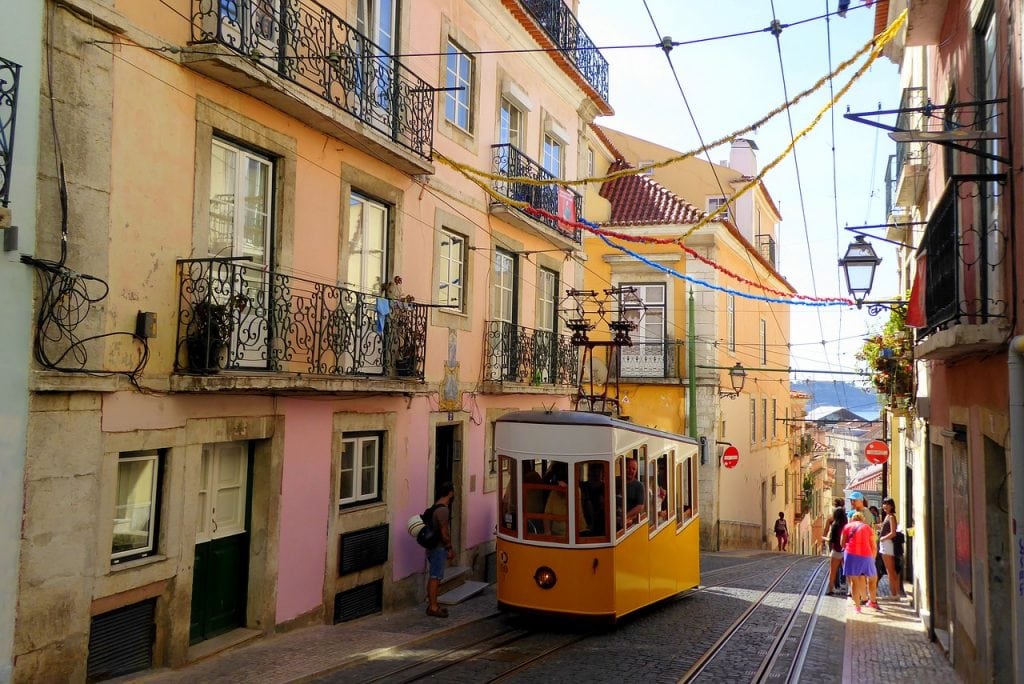 A yellow tram on the streets of Lisbon, Portugal on a sunny summer day.