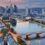 An aerial view of Frankfurt city with lit up bridges crossing over a central river.