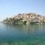 Populated island filled with buildings and greenery surrounded by a body of water