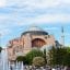 Daytime view of Hagia Sophia in Istanbul, framed by minarets and greenery with a fountain in the foreground—an iconic landmark along the route from Istanbul Airport to SAW Airport.