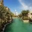 waterway in dubai with green water and big hotel in the distance