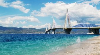 View of Patras Bridge suspended over clear-blue waters.