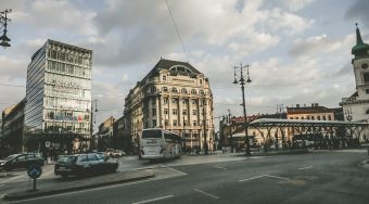 A view of a city street in Budapest with cars and buses.