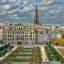 Brussels courtyard and ornate building under a blue and white cloudy sky.