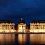 Bordeaux buildings and waterway lit up at night.
