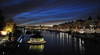 night view of lights and a boat under a very dark sky
