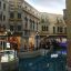 A canal running through the middle of a cluster of colonial type buildings painted a butter yellow.