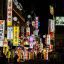 colourful neon signs lit up along a busy street in Seoul