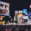 Buildings in downtown Tokyo lit up in bright neon lights.