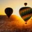 hot air balloons fly in a sunset sky in Cappadocia