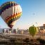 Hot air balloons flying across the valley in Cappadocia.