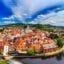 View of Cesky Krumlov with a river and lush green trees surrounding it.