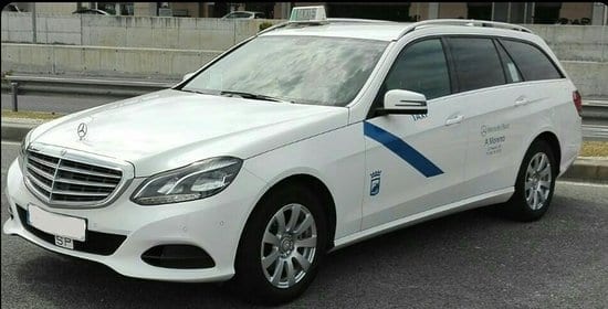 Taxi Malaga Malaga taxi that is white with a blue stripe.