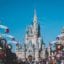 A blue and white castle with turrets and towers surrounded by a crowd of people.