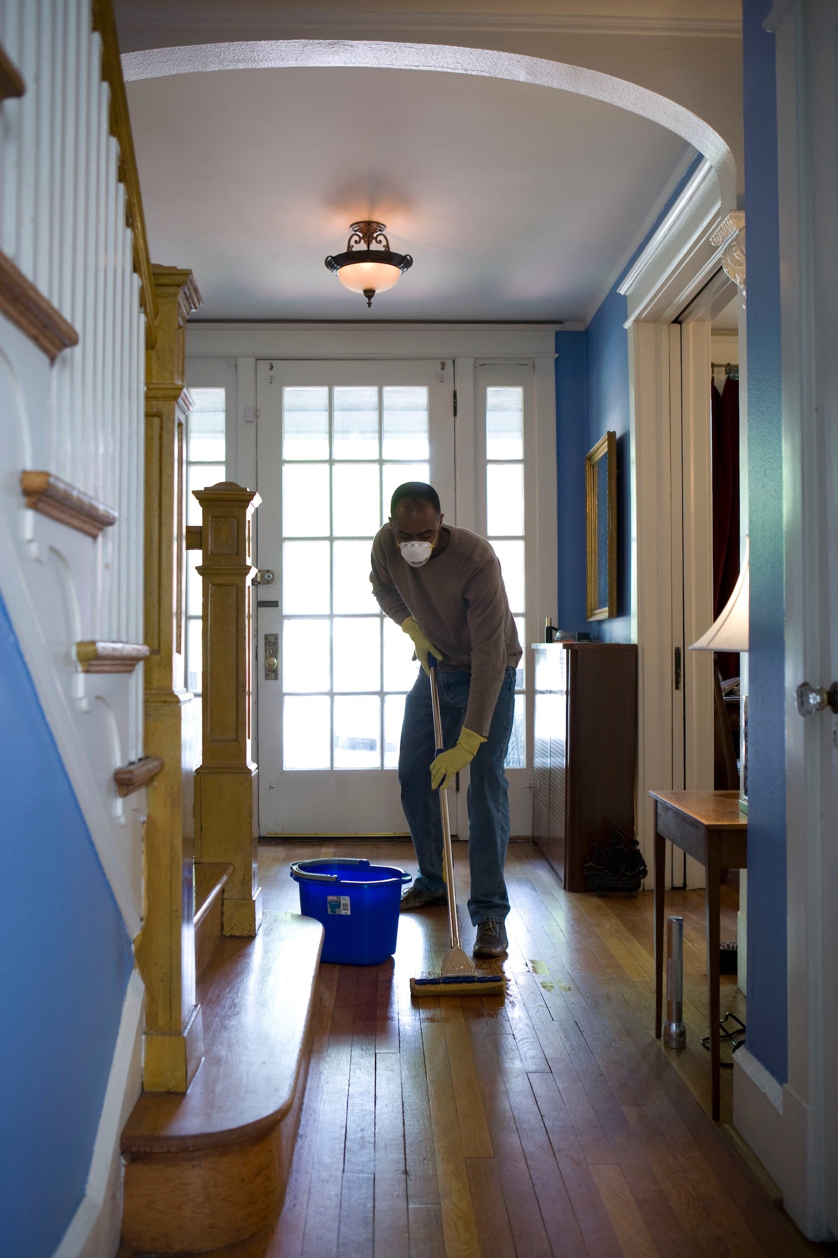 african american man cleaning hallway in vacation rental home