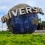 The Universal Studios sign, a large blue globe with 'Universal' lettering wrapped around it, with lots of greenery around it.