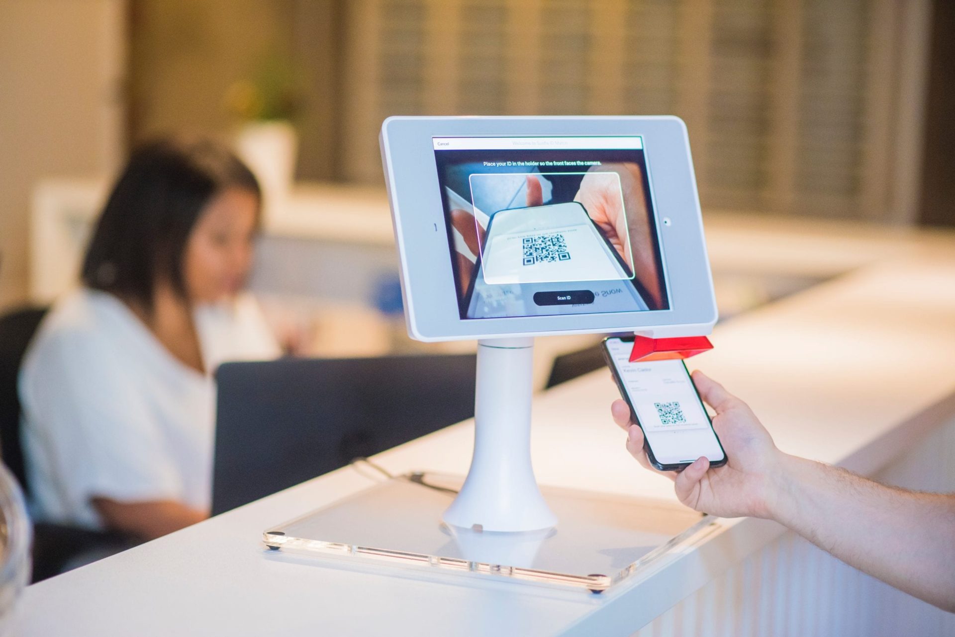 person performing contactless check-in at hotel front desk using their smartphone