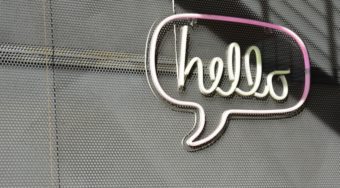 neon sign reading hello in a speech bubble