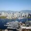 An aerial view of Vancouver City looking over the bay with high-rise buildings in the background and the harbour in the foreground.