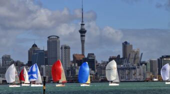 Sailboats in front of Auckland city buildings