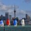 Sailboats in front of Auckland city buildings
