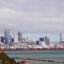 Auckland city on horizon, filled with skyscrapers over a body of water.