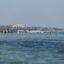 A sea view with boats and buildings in the far distance.