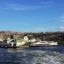 A cityscape on blue sky horizon with a body of water and boats