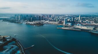 Aerial view of San Diego and it's blue ocean and skyscrapers rising in the background.