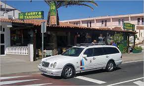 Fuerteventura taxi white station wagon car with dark blue and light blue stripes on front door operating as taxi in Fuerteventura