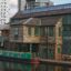 the classic canal house by the canal situated near modern buildings shot at daytime