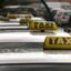 cabs lining up with photograph focusing on taxi tops and signage