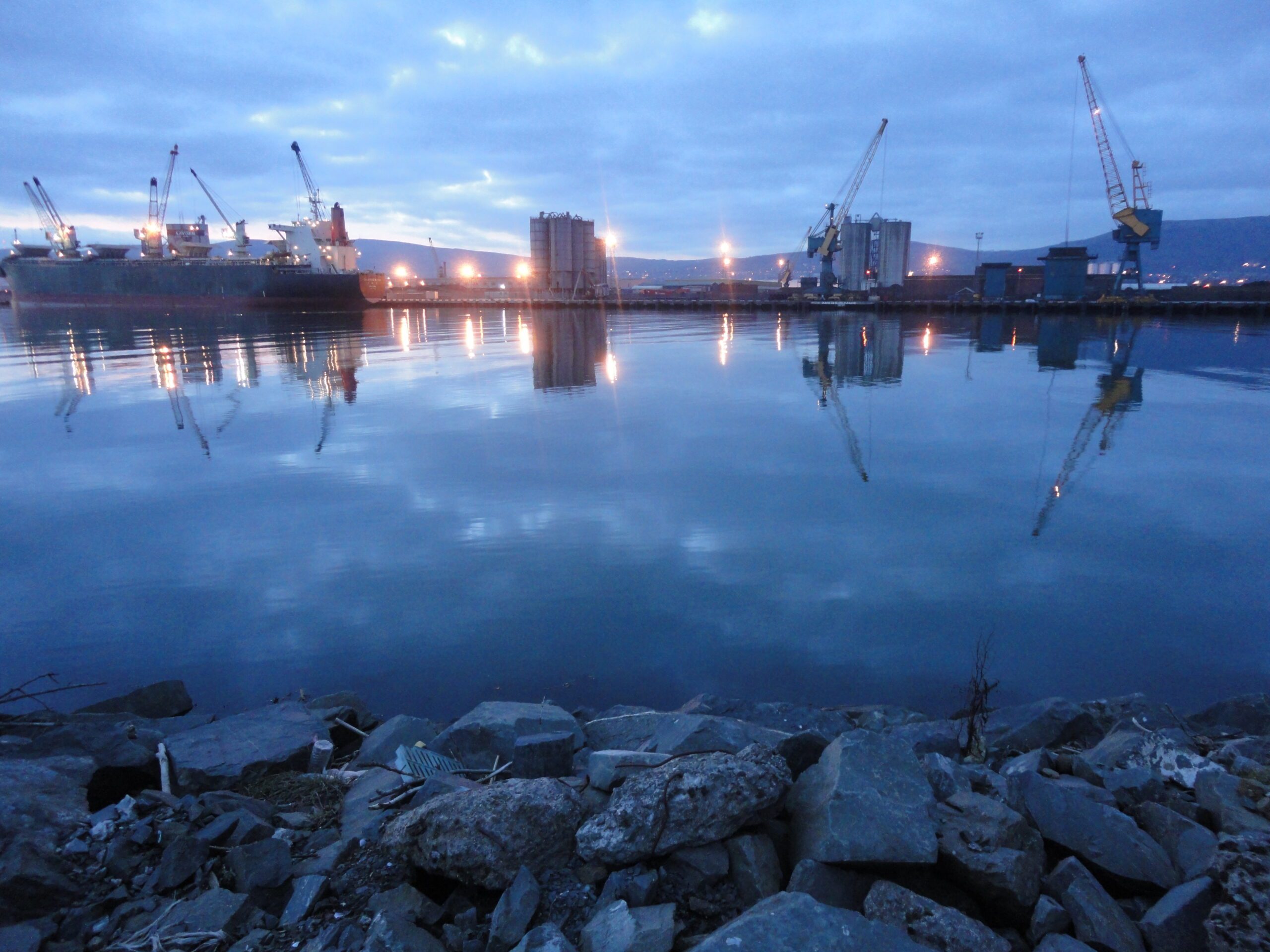 water and airport buildings under a cloudy sky