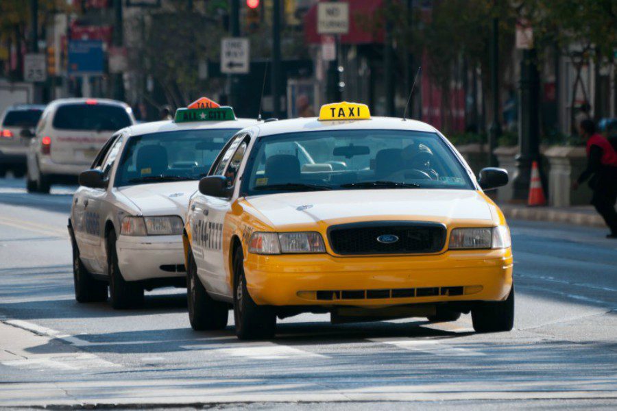 Philadelphia taxi A yellow and a white Philadelphia taxi roaming the streets in Philadelphia