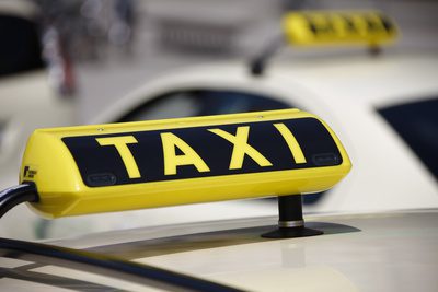 Taxi Frankfurt - Welcome Pickups A taxi Frankfurt with its signature yellow and black taxi sign on pale yellow taxi roof.