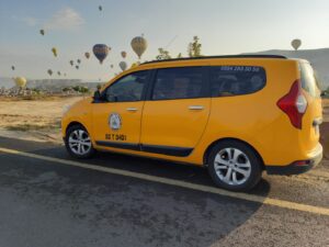 Cappadocia taxi large dark yellow taxi vehicle parked on the side of the street near field