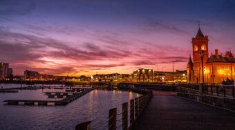lighted parliament buildings situated by body of water and photographed after golden hour